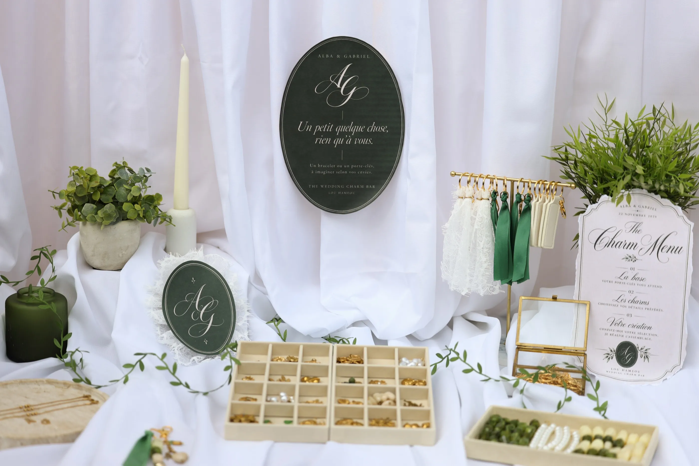 Le Charm Bar dressé en blanc et vert olive : drapé, Charm Menu, plateaux de charms dorés