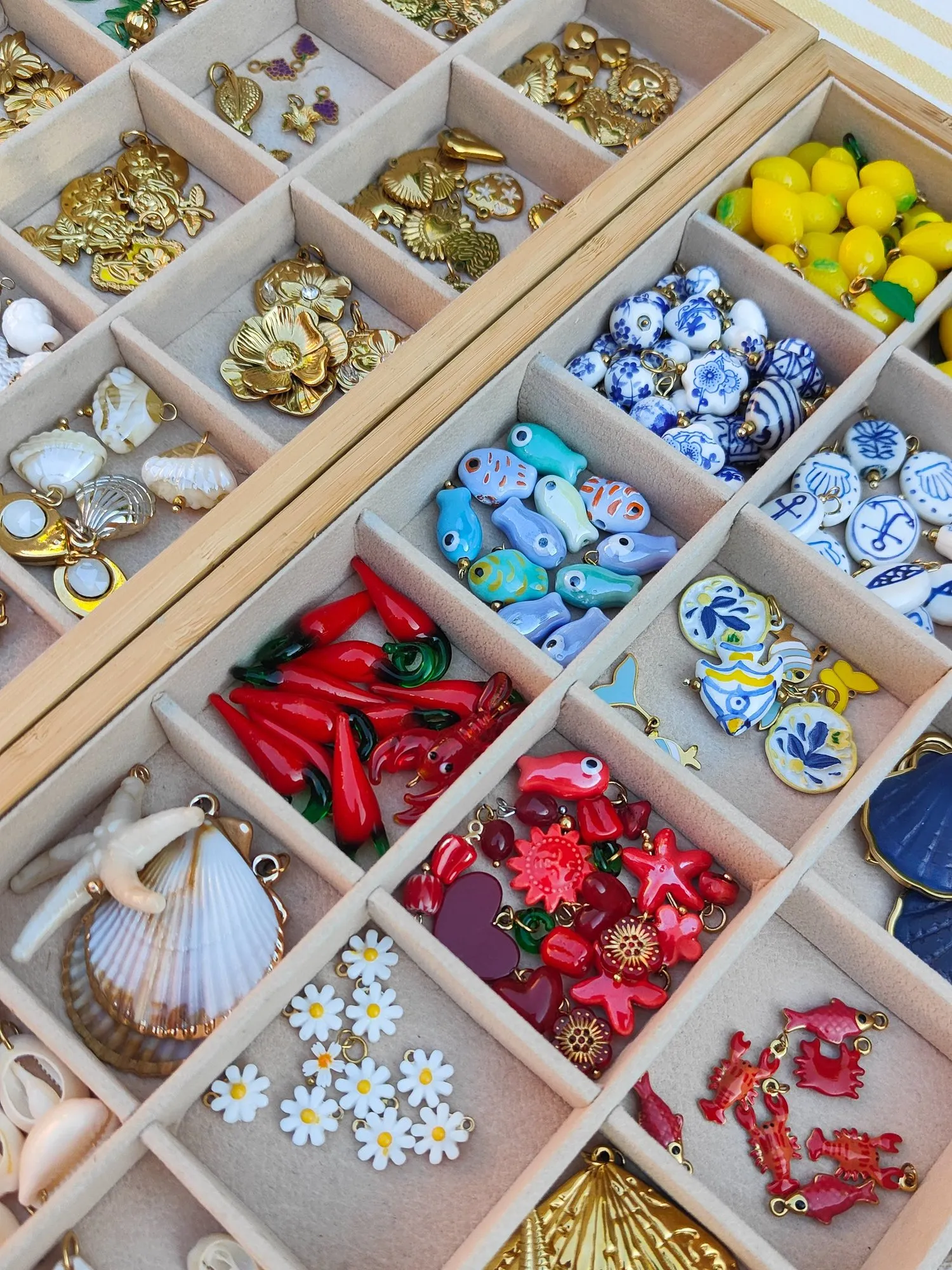 Les plateaux de charms : citrons, céramiques bleues, coraux rouges, coquillages et marguerites