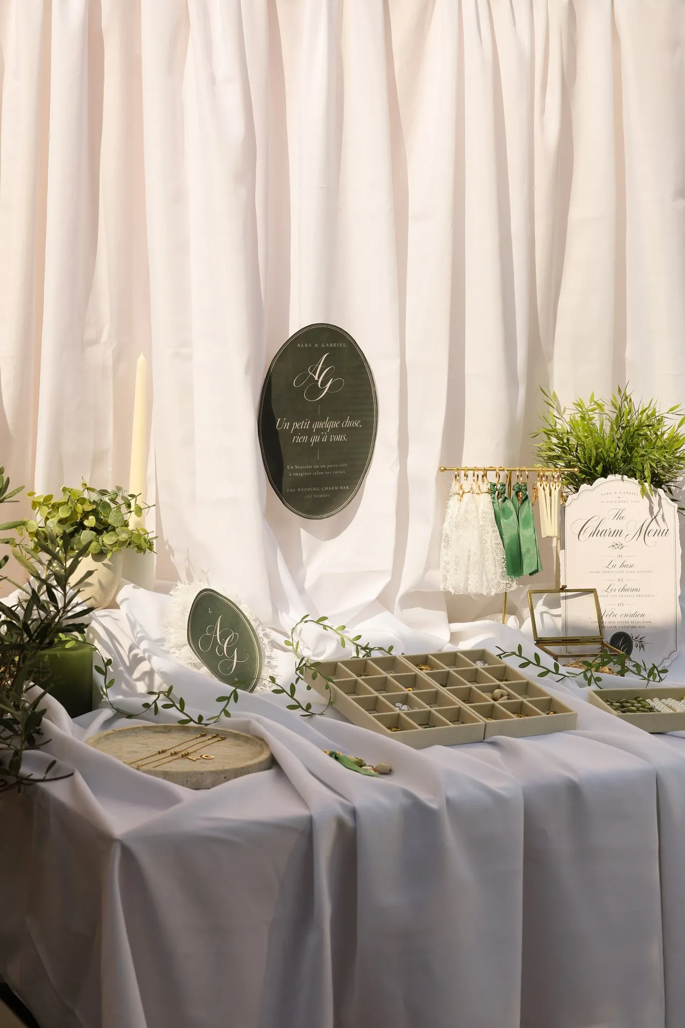 La table complète du Charm Bar : drapé blanc, panneau de monogramme et plateaux