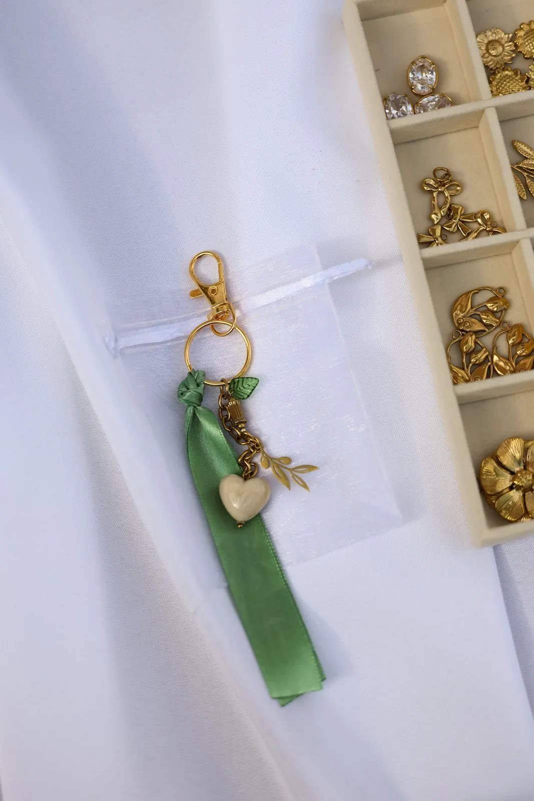 Le porte-clés terminé : ruban vert, perles de verre et cœur doré