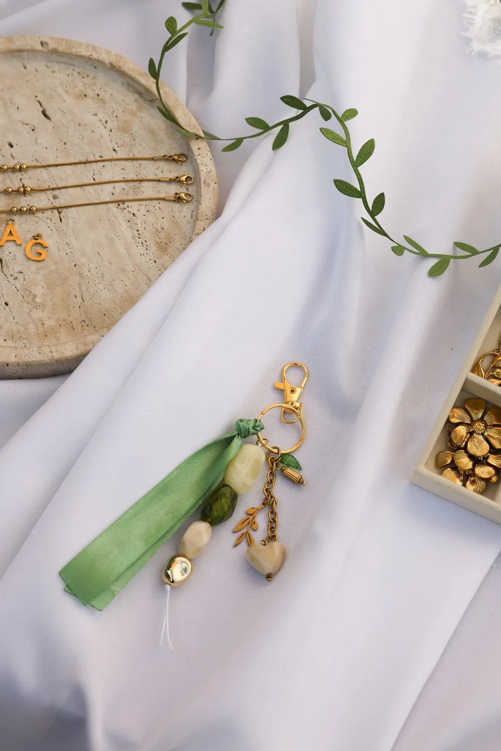 Le même porte-clés, perles de verre vertes et breloque dorée