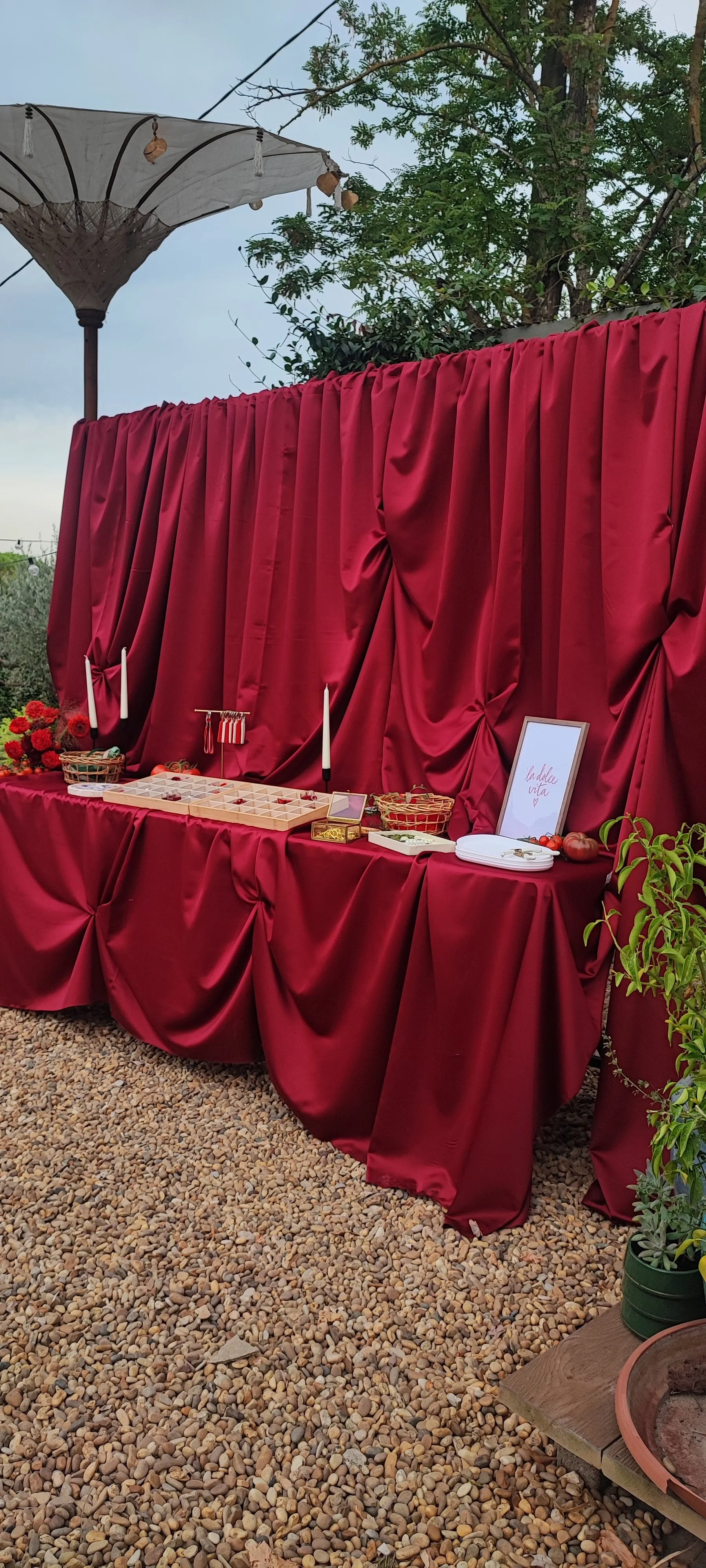 La table du Charm Bar en draperie bordeaux, sous un parasol, face au jardin
